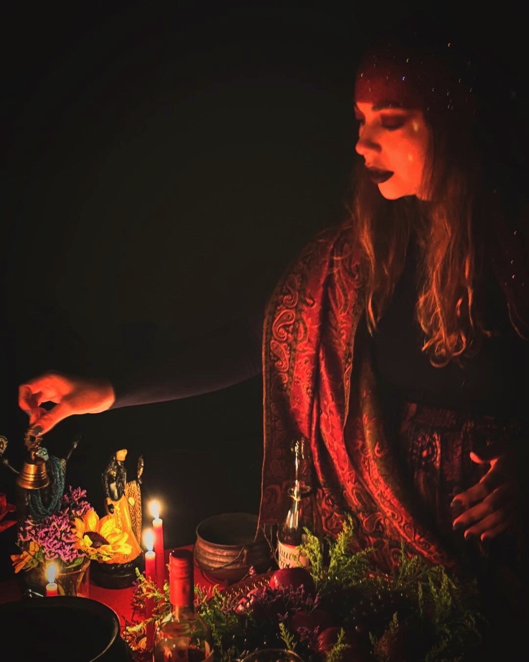 Isadora Maia preparando o altar do ritual à luz de velas